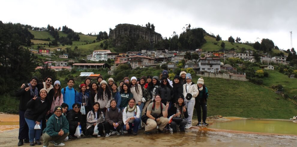 Grupo de turistas sonrientes durante el tour “Sol de Altura: Festival y Chimborazo”, disfrutando del Festival de Verano en Salinas de Guaranda, rodeados de coloridos puestos de quesos, chocolates y tejidos artesanales. Más tarde, caminando en el páramo andino hacia el mirador “El Gavilán”, con vistas panorámicas del volcán Chimborazo cubierto de nieve bajo un cielo despejado. Paisajes naturales, cultura ancestral y actividades de aventura se combinan en este viaje de dos días que conecta la tradición andina con la majestuosidad de la montaña más alta de Ecuador.